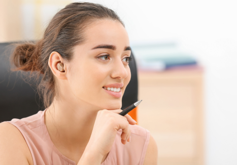 Jovem sorridente representando os benefícios do aluguel de aparelho auditivo para qualidade de vida no trabalho