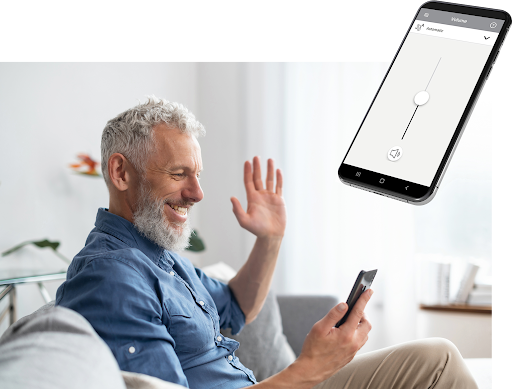 Paciente em casa usando o aplicativo Hearing Remote no celular para ajustar o aparelho auditivo